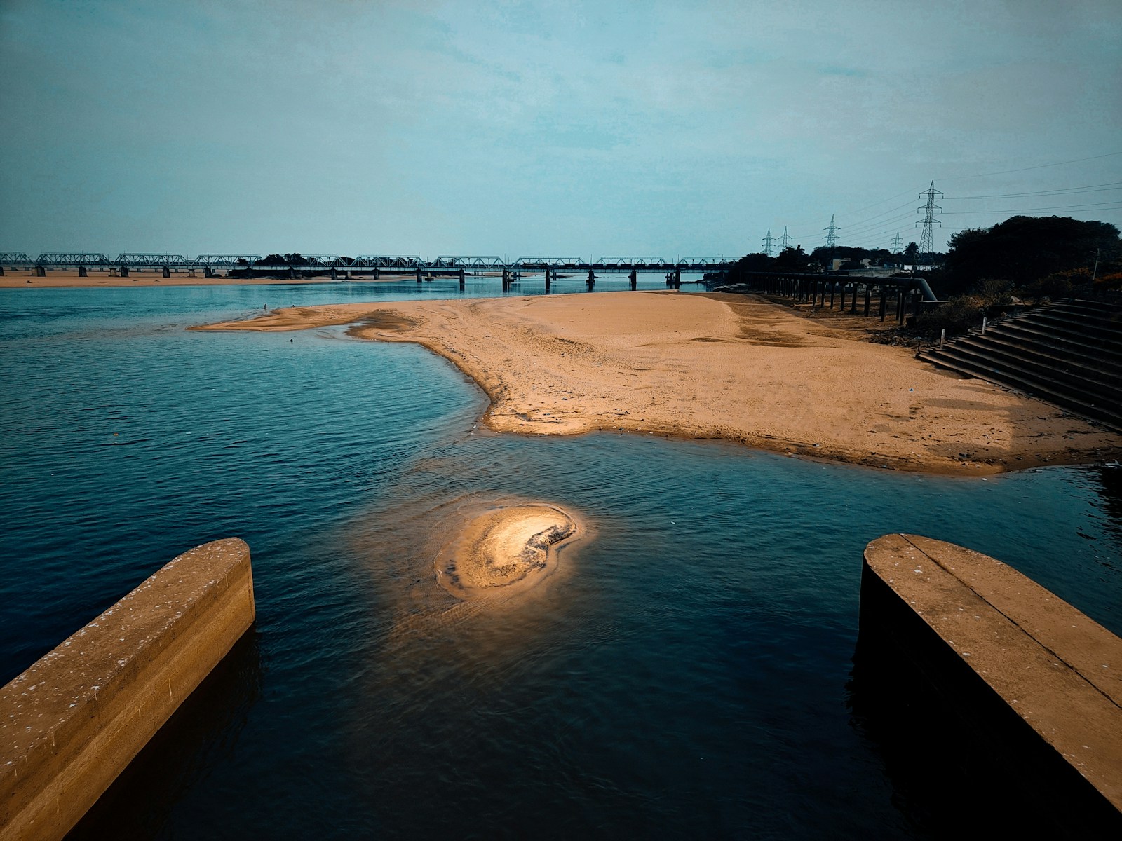 a body of water with a bridge in the background