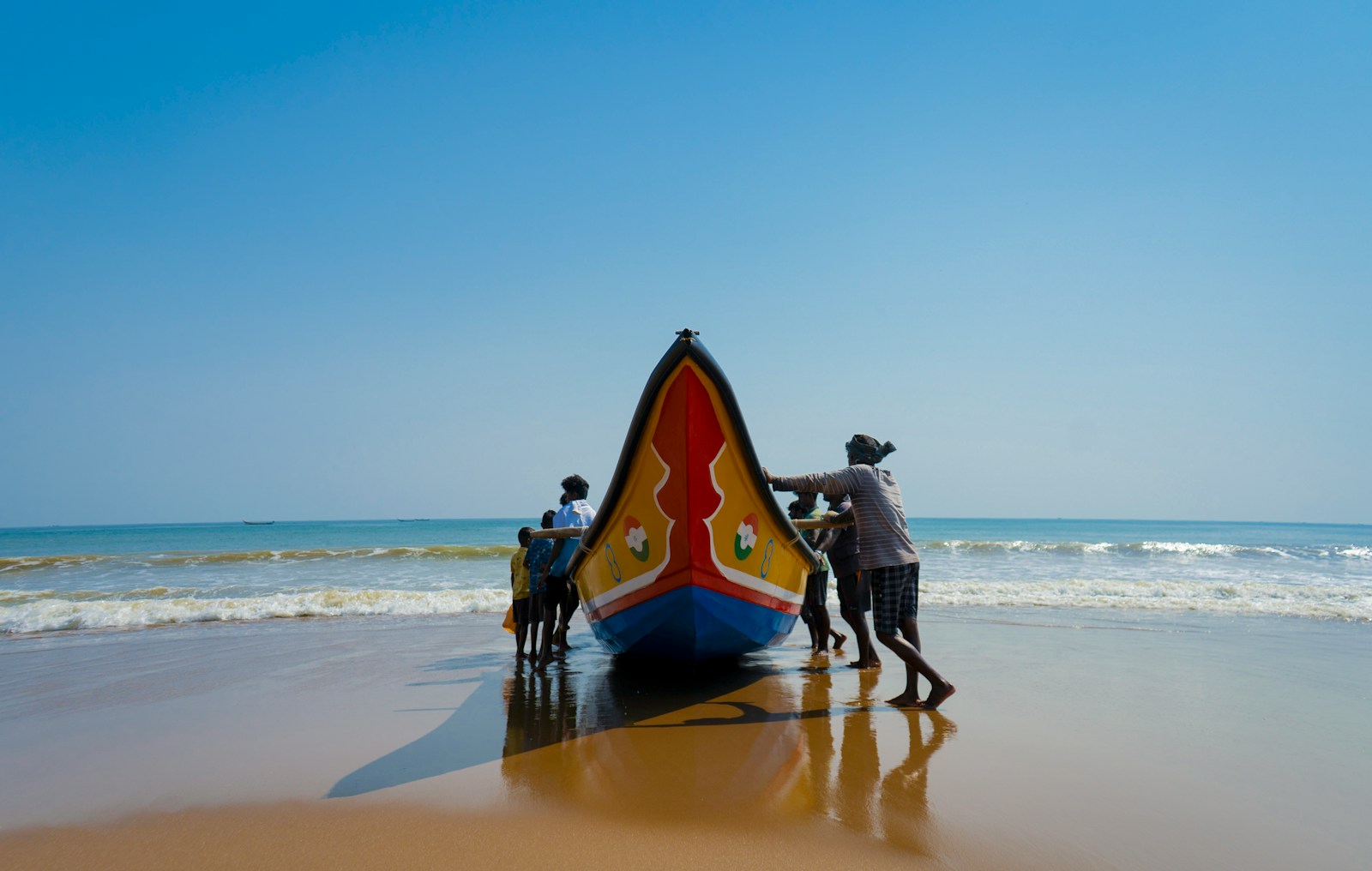 a group of people standing next to a boat on a beach