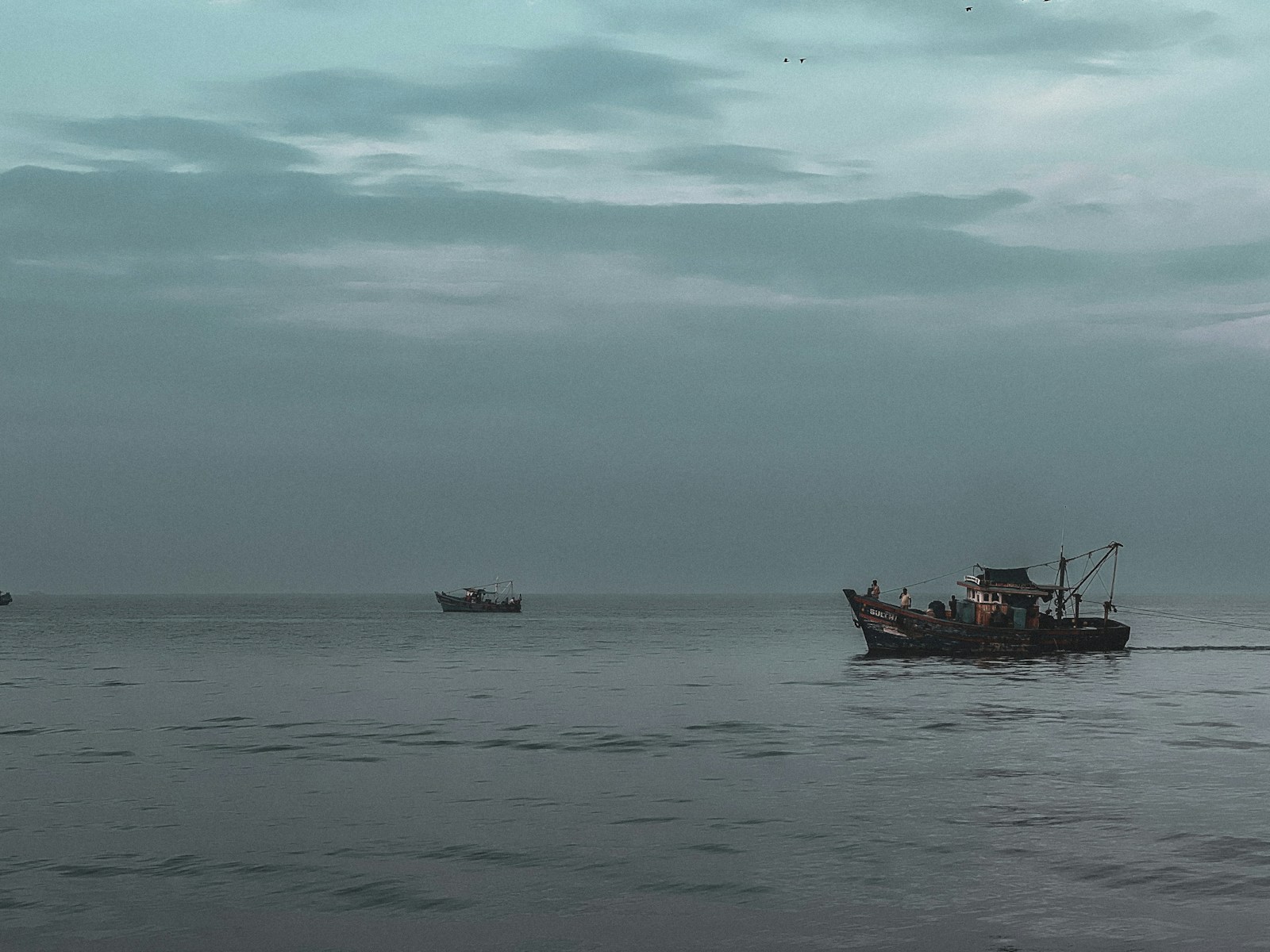 a couple of boats floating on top of a large body of water