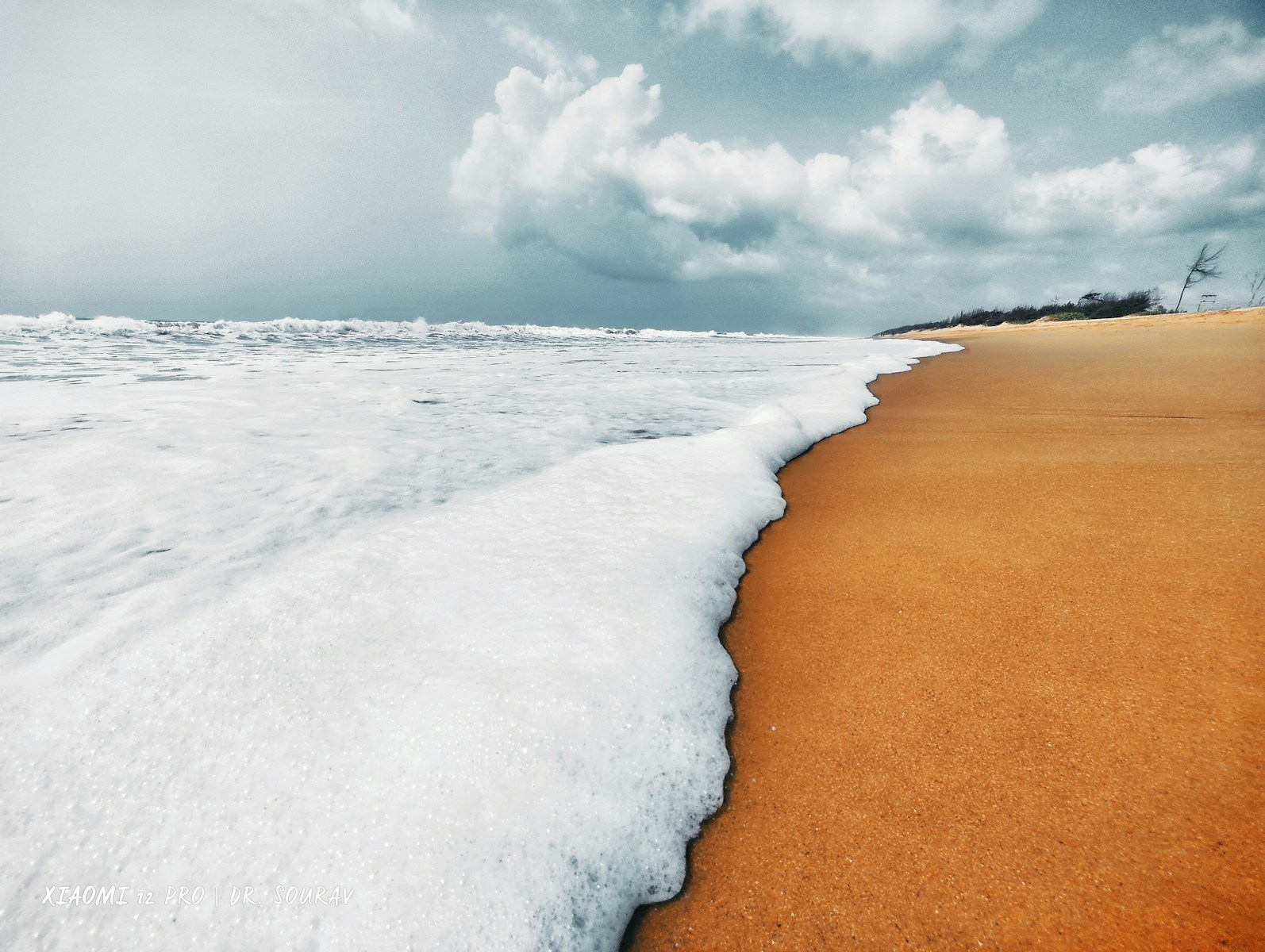 a sandy beach with waves crashing on it