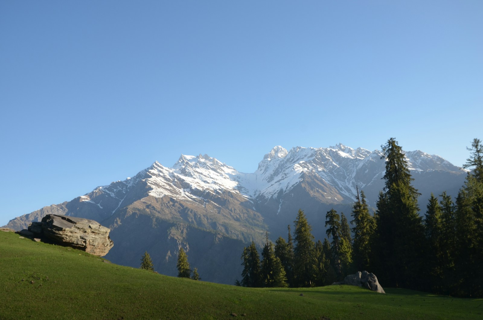 white and green mountain and gray rock near green trees