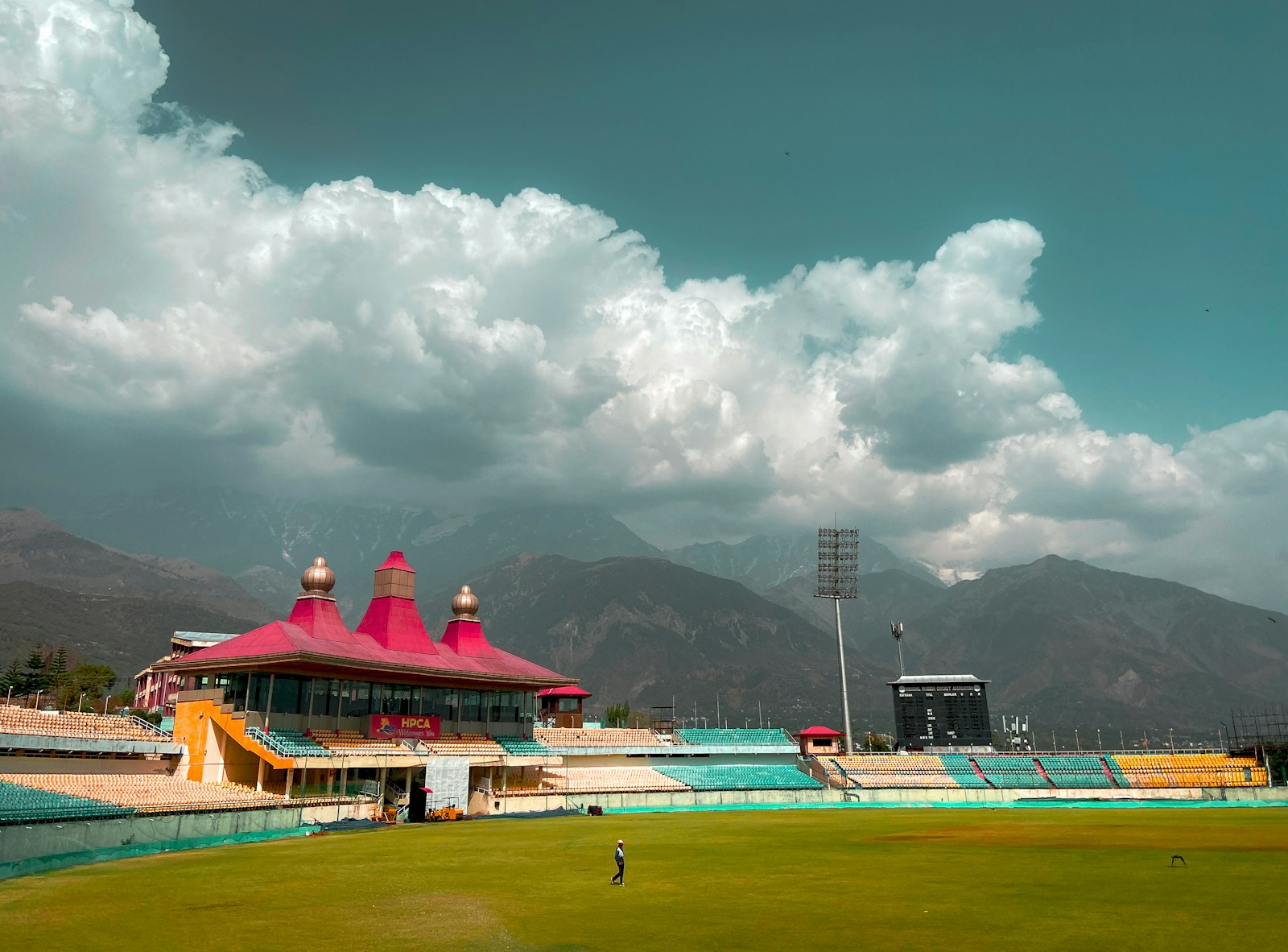 people playing soccer on field under white clouds and blue sky during daytime