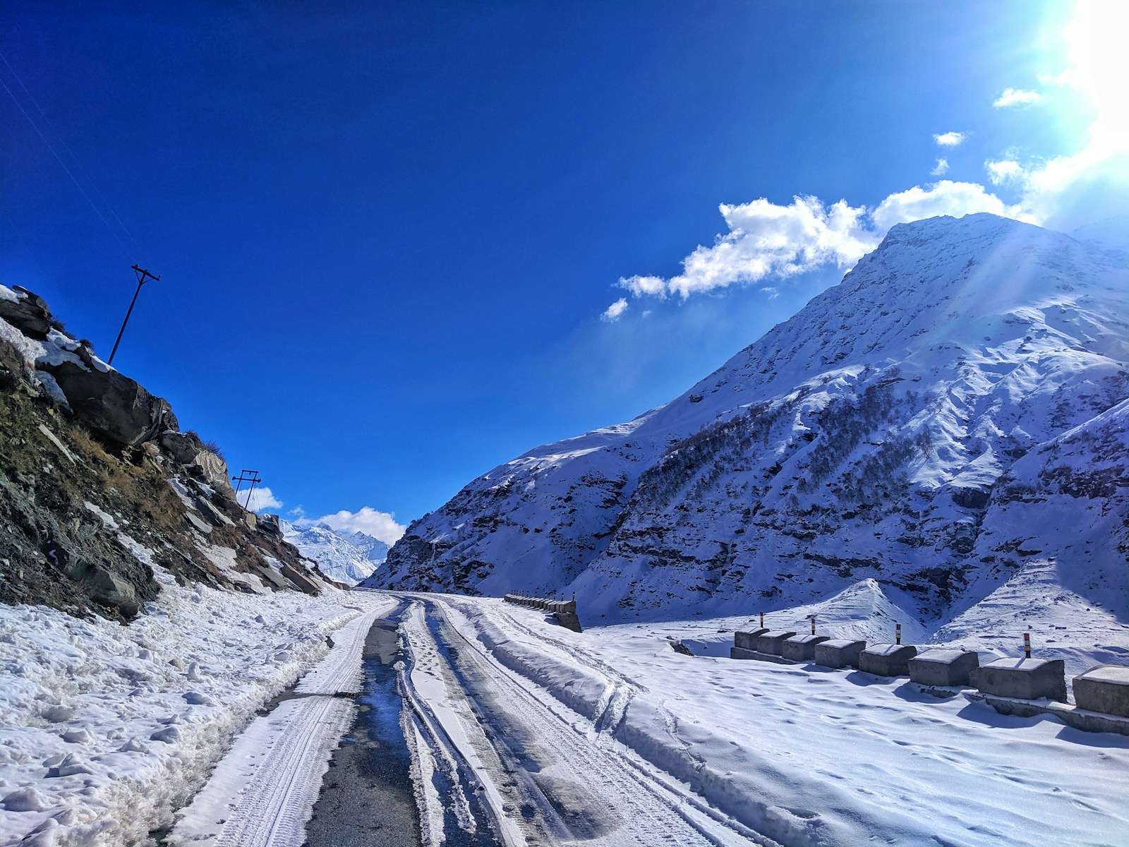 a snow covered road with a mountain in the background