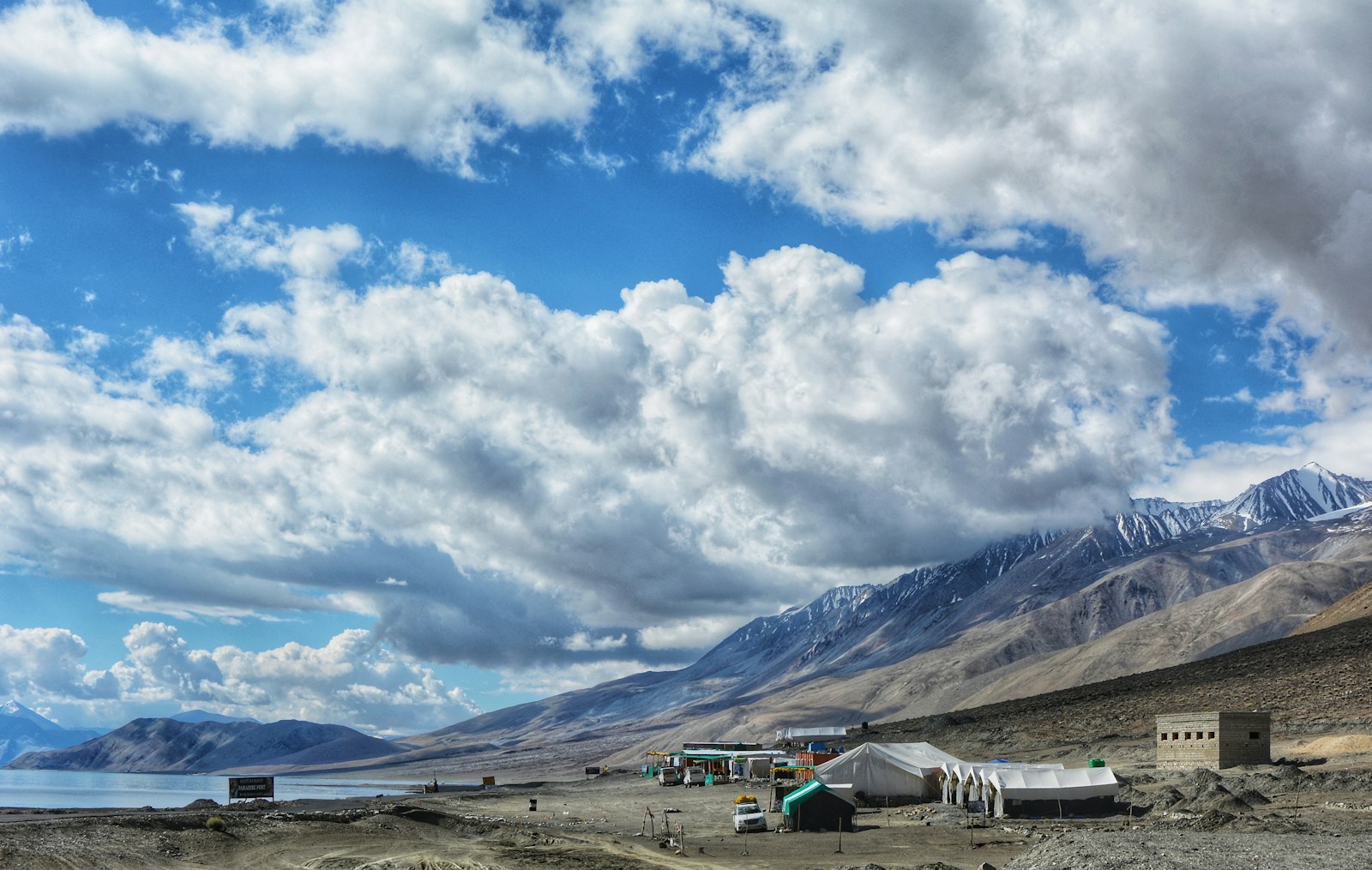 white and black house on brown field under white clouds and blue sky during daytime