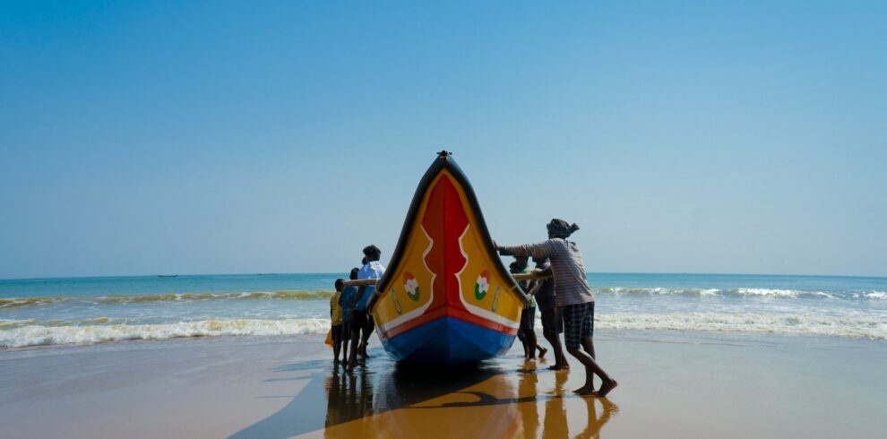 a group of people standing next to a boat on a beach