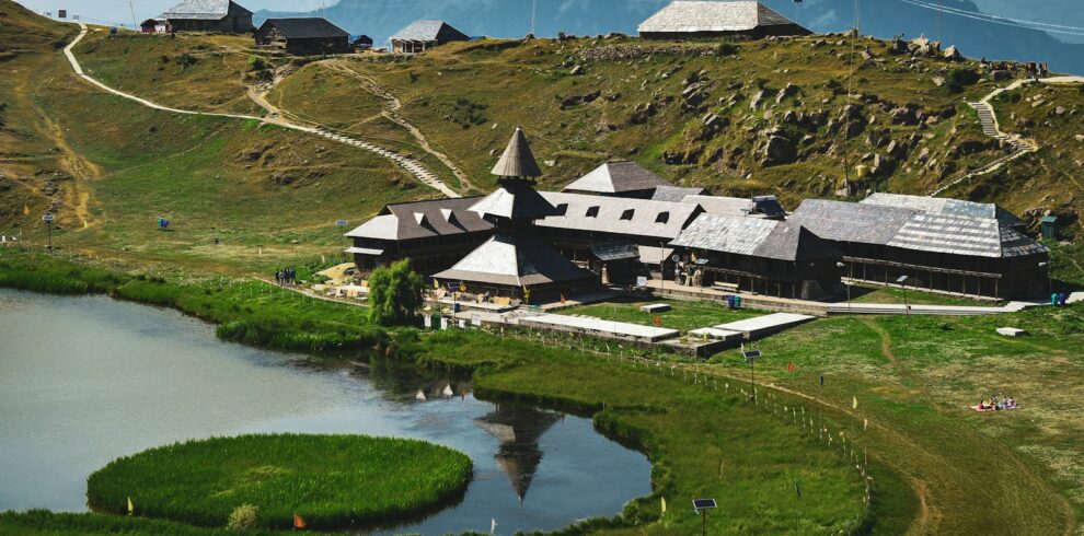 a house on a hill with a lake in front of it