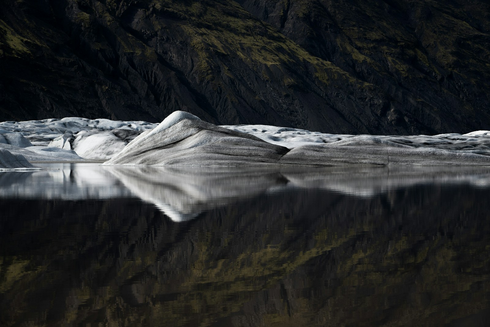 a large body of water with a mountain in the background